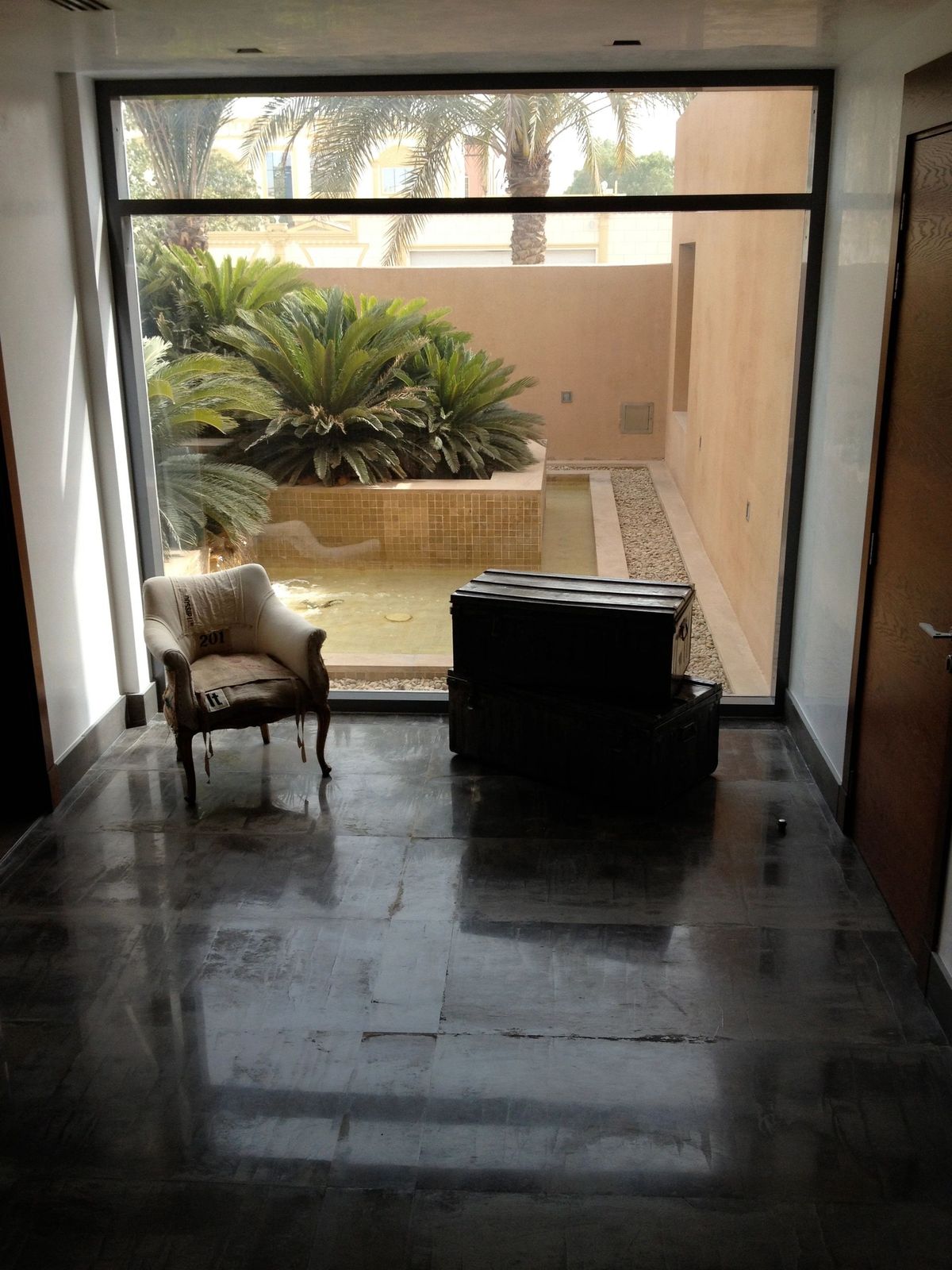 Stone hallway opening onto a planted courtyard, designed by Simoni Santamarina Studio
